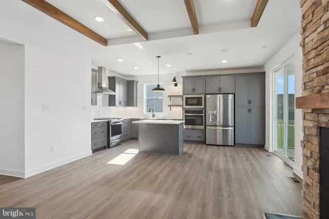 a kitchen with stainless steel appliances a refrigerator sink and wooden floor