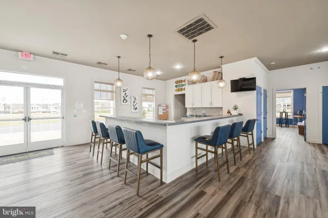 a kitchen with stainless steel appliances granite countertop a stove a refrigerator a kitchen island with a dining table and chairs with wooden floor