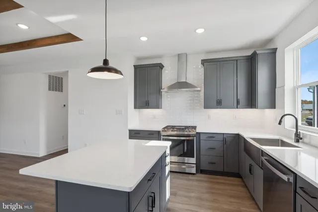 a kitchen with stainless steel appliances granite countertop a sink a stove and a refrigerator