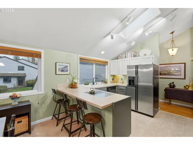 a kitchen with stainless steel appliances a table and chairs