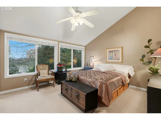 a bedroom with a bed a large window with table and chairs