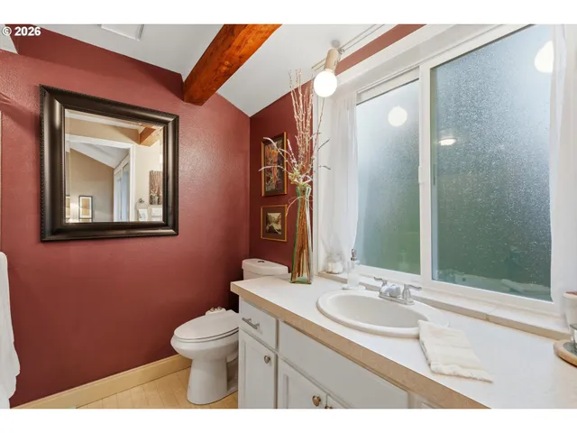 a bathroom with a toilet a sink and mirror
