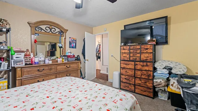 a bedroom with a bed and a flat tv screen on dresser