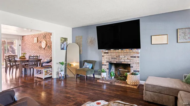 a living room with furniture a fireplace and a flat screen tv
