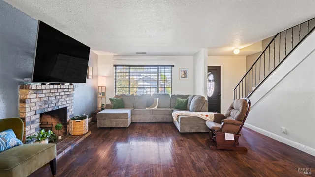 a living room with furniture a flat screen tv and a fireplace