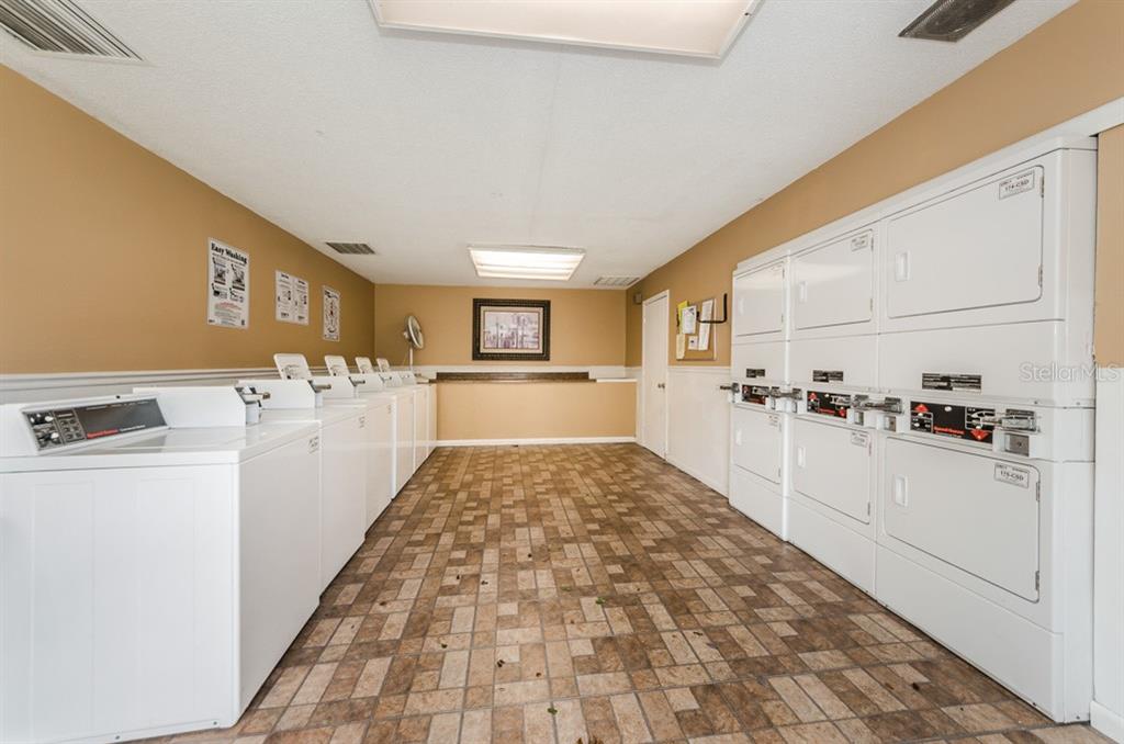 455 Alt 19, Unit 92 Palm Harbor, FL 34683 - Photo 5 of 19 a view of a kitchen with kitchen island wooden floors appliances and windows