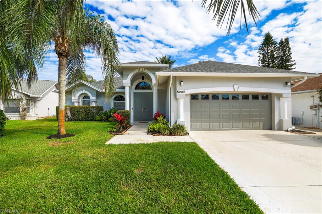 5235 Malvern Court Naples, FL 34112 - Photo 3 of 28 a front view of a house with a yard and palm tree