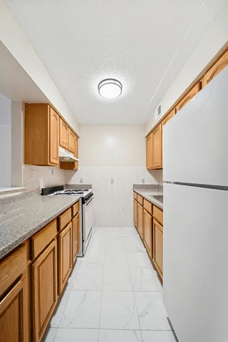 a large kitchen with stainless steel appliances granite countertop a sink and cabinets