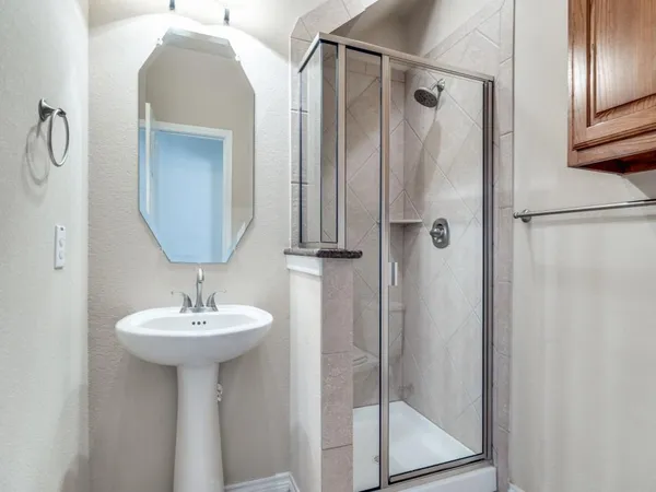 a bathroom with a sink mirror and shower