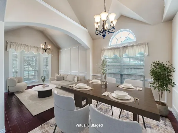 a view of a dining room with furniture a chandelier and wooden floor