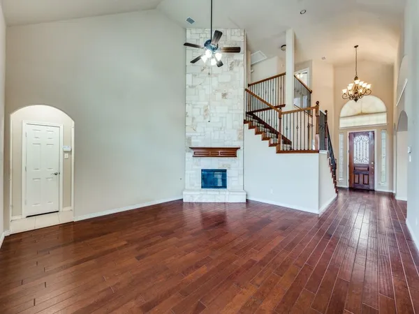 a view of a hallway with wooden floor and staircase