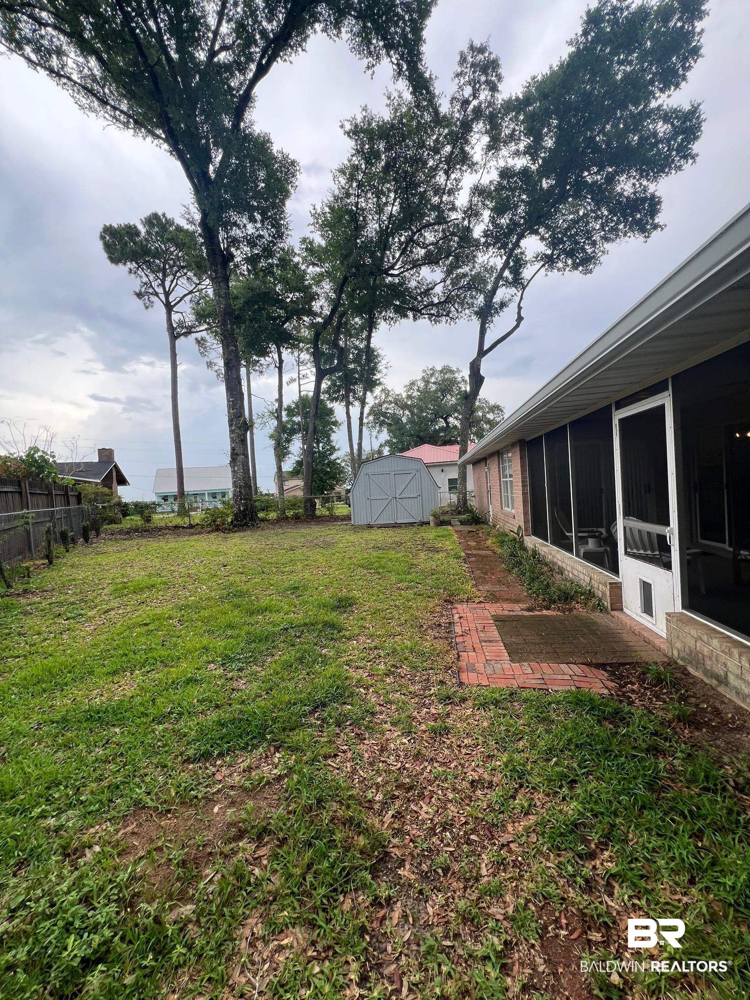 2204 Club House Drive Lillian, AL 36549 - Photo 19 of 38 View of yard with a sunroom and a storage shed