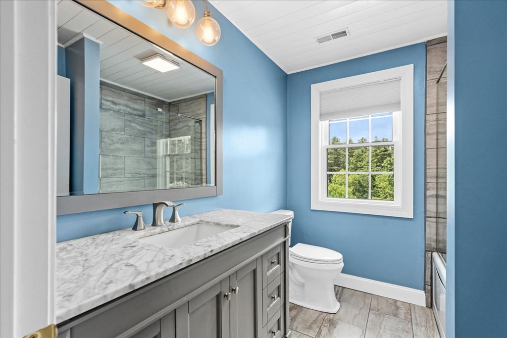 2 Harding Lane Sturbridge, MA 01518 - Photo 27 of 42 a bathroom with a granite countertop sink toilet a mirror and a tub