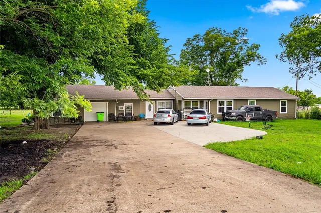 a front view of a residential houses with yard and green space