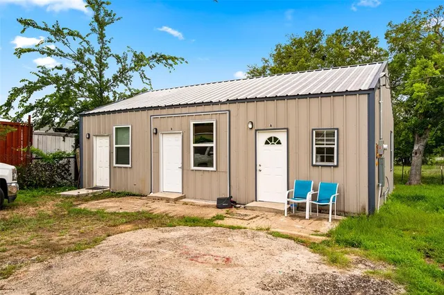 a view of a house with a tree and a yard