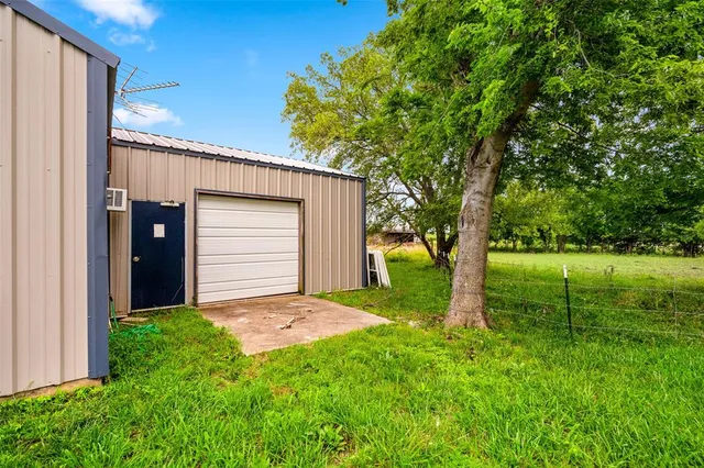 a view of a house with a big yard plants and large trees