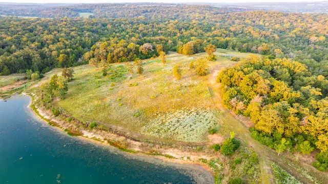 an aerial view of residential houses with outdoor space and trees