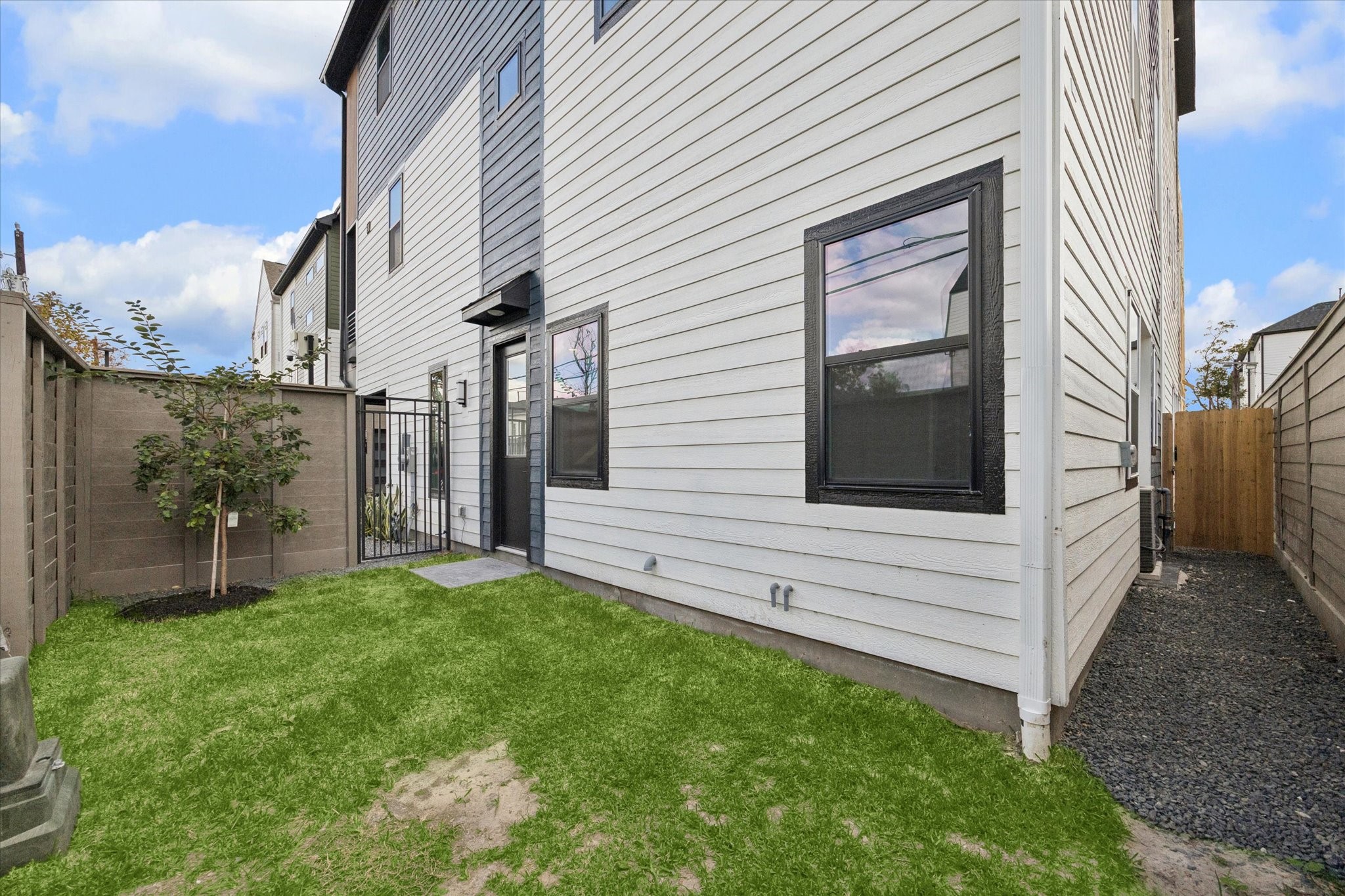817 Thornton Road, Unit G Houston, TX 77018 - Photo 19 of 49 a view of a white house with a small yard and wooden fence
