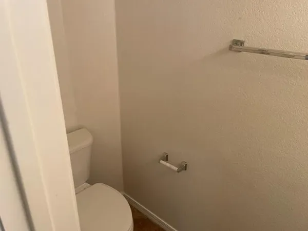 a white toilet sitting next to a shower