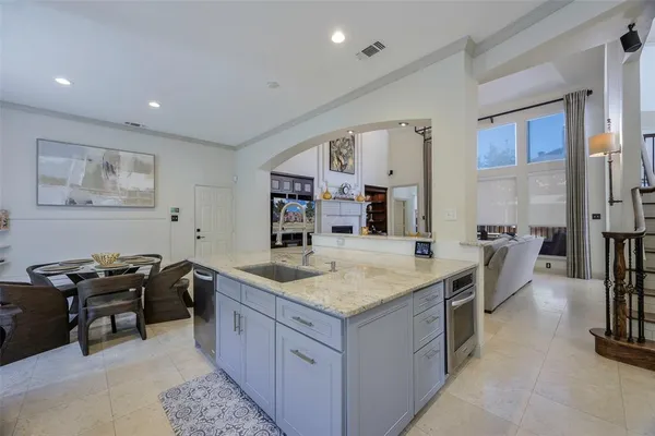 a dining hall with stainless steel appliances granite countertop a sink and a refrigerator
