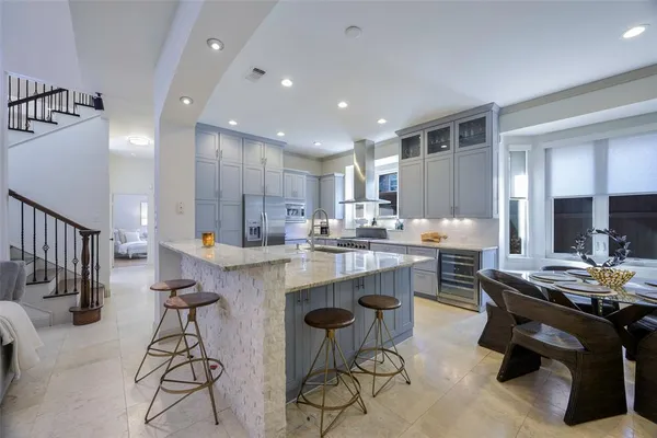 a kitchen with a table chairs refrigerator and cabinets