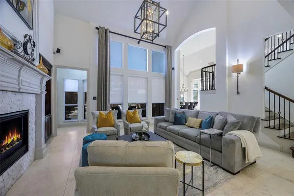 a living room with furniture a fireplace and a chandelier