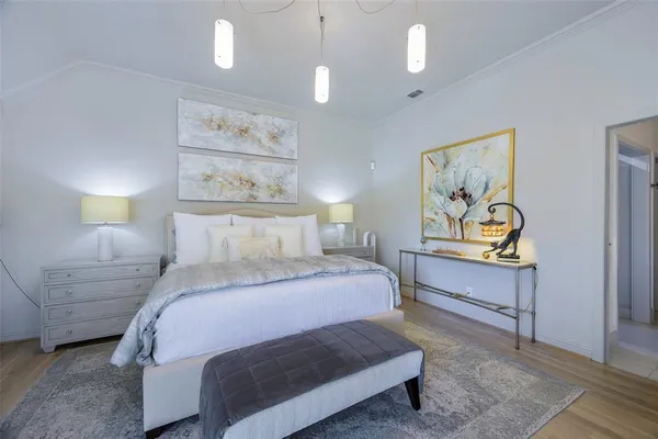 a bedroom with a bed and painting on the wall