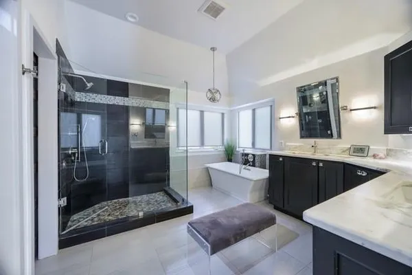 a large bathroom with a double vanity sink a large mirror and shower