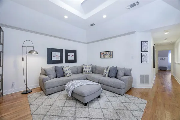 a living room with furniture and a wooden floor