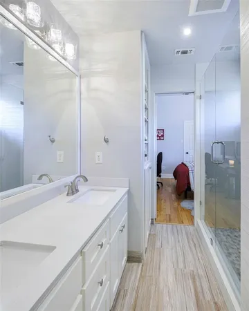 a en suite bathroom with a double vanity sink and a mirror