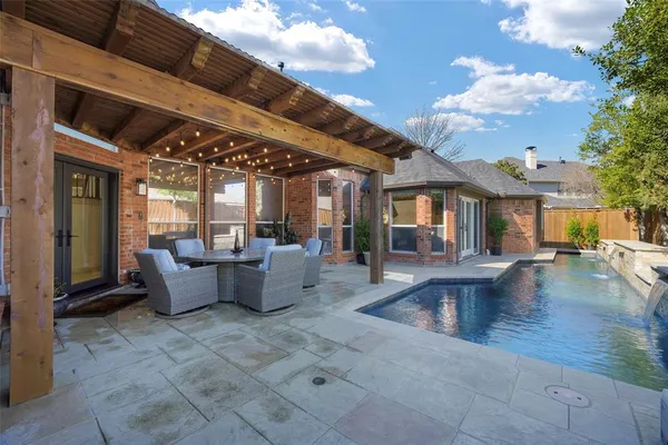 a view of a patio with couches table and chairs with wooden floor and fence