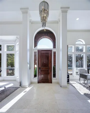 a view of a hallway with windows and chandelier
