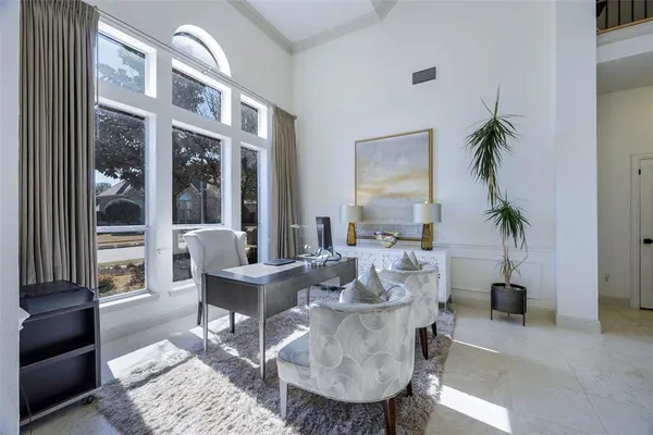 a living room with furniture a large window and a potted plant