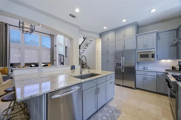 a kitchen with stainless steel appliances granite countertop a sink and refrigerator