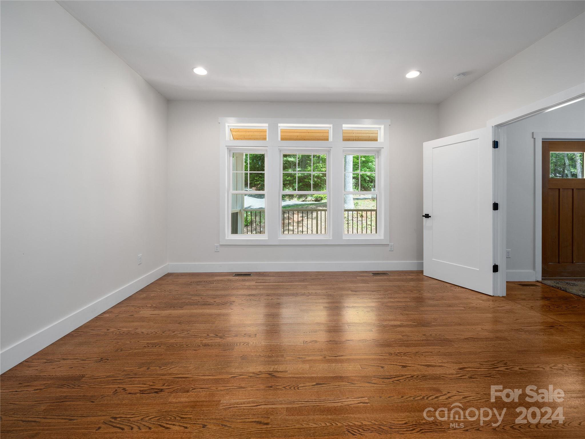 359 Tiptop Road Brevard, NC 28712 - Photo 12 of 48 an empty room with wooden floor and windows