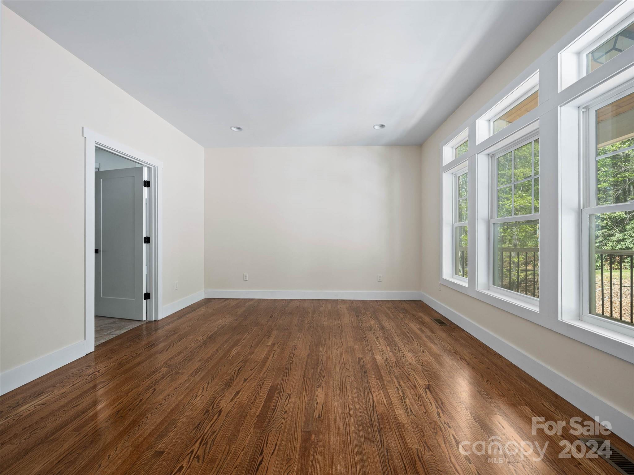 359 Tiptop Road Brevard, NC 28712 - Photo 13 of 48 a view of an empty room with wooden floor and a window