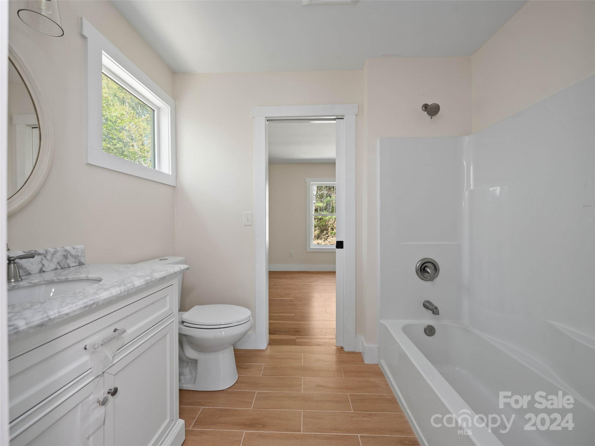 359 Tiptop Road Brevard, NC 28712 - Photo 29 of 48 a bathroom with a granite countertop toilet a sink and bathtub