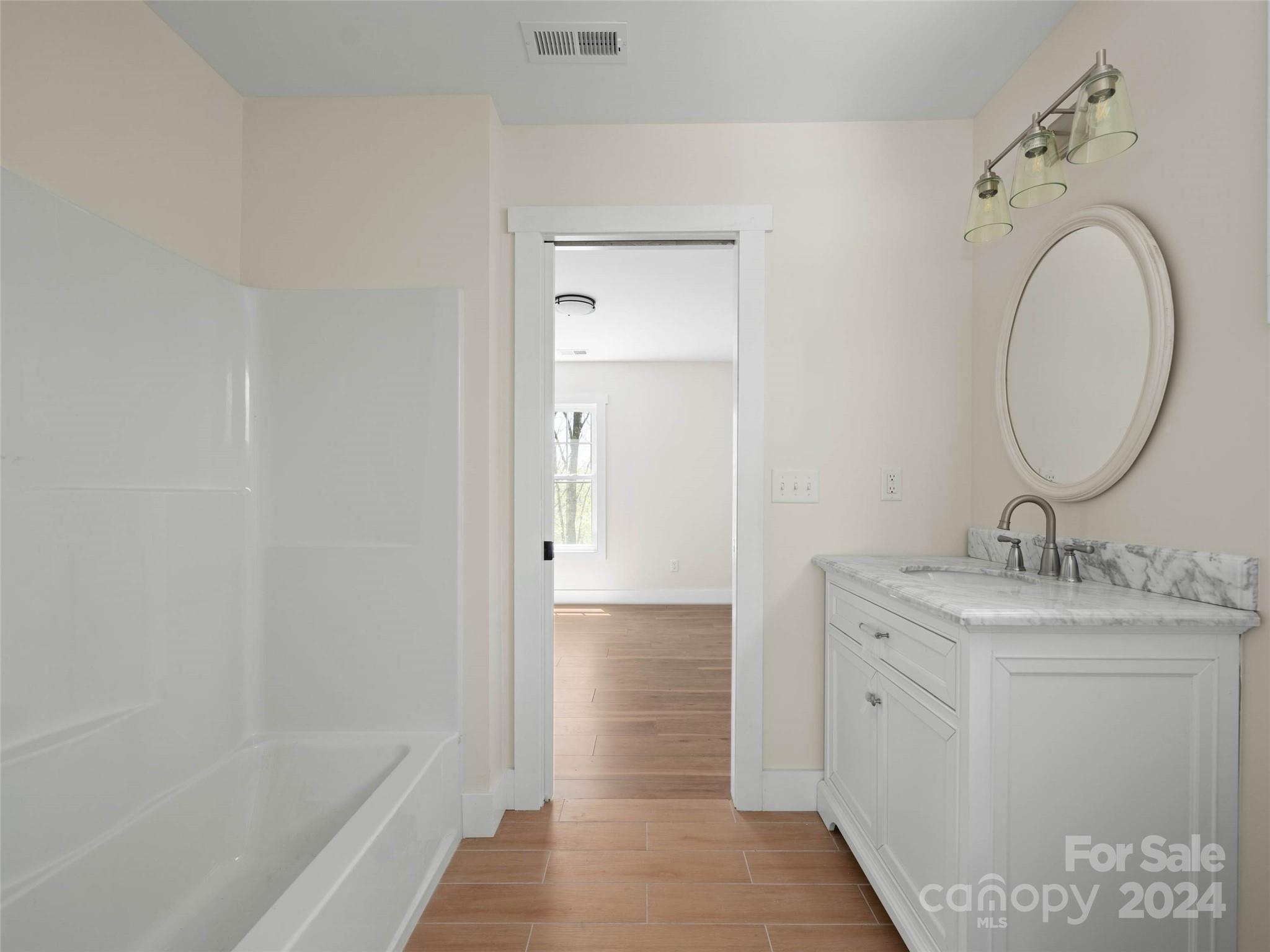 359 Tiptop Road Brevard, NC 28712 - Photo 30 of 48 a bathroom with a granite countertop sink a mirror and a bathtub