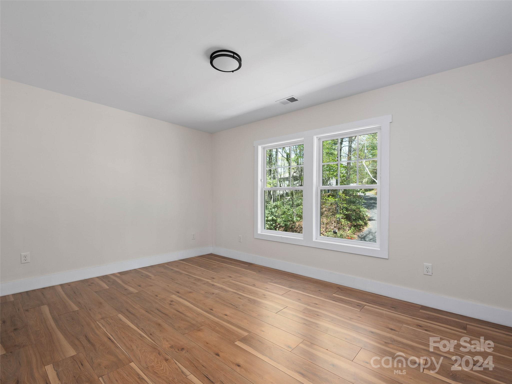 359 Tiptop Road Brevard, NC 28712 - Photo 31 of 48 an empty room with wooden floor and windows