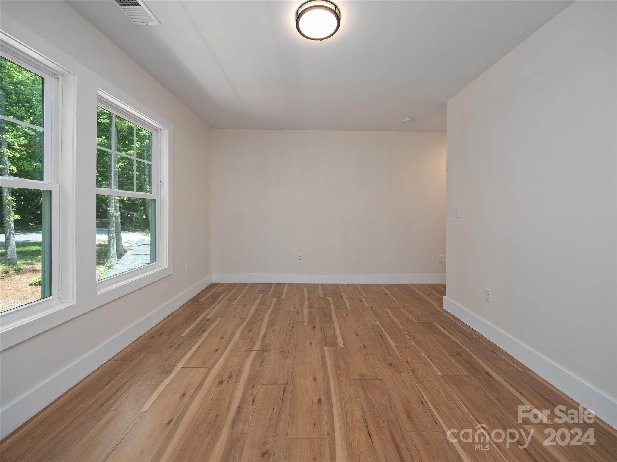 359 Tiptop Road Brevard, NC 28712 - Photo 33 of 48 an empty room with wooden floor and windows