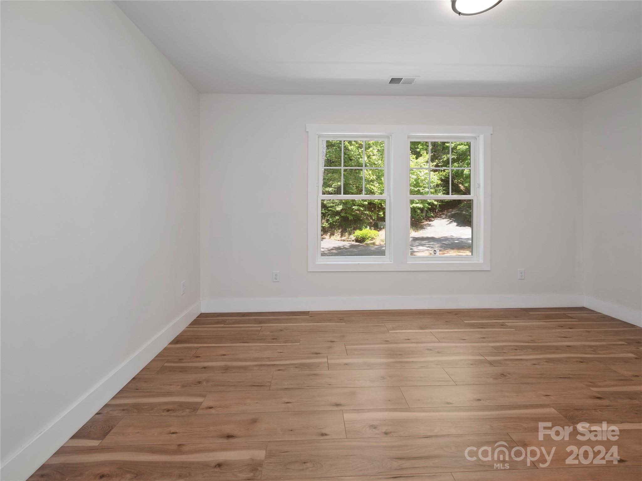 359 Tiptop Road Brevard, NC 28712 - Photo 34 of 48 a view of an empty room with wooden floor and a window