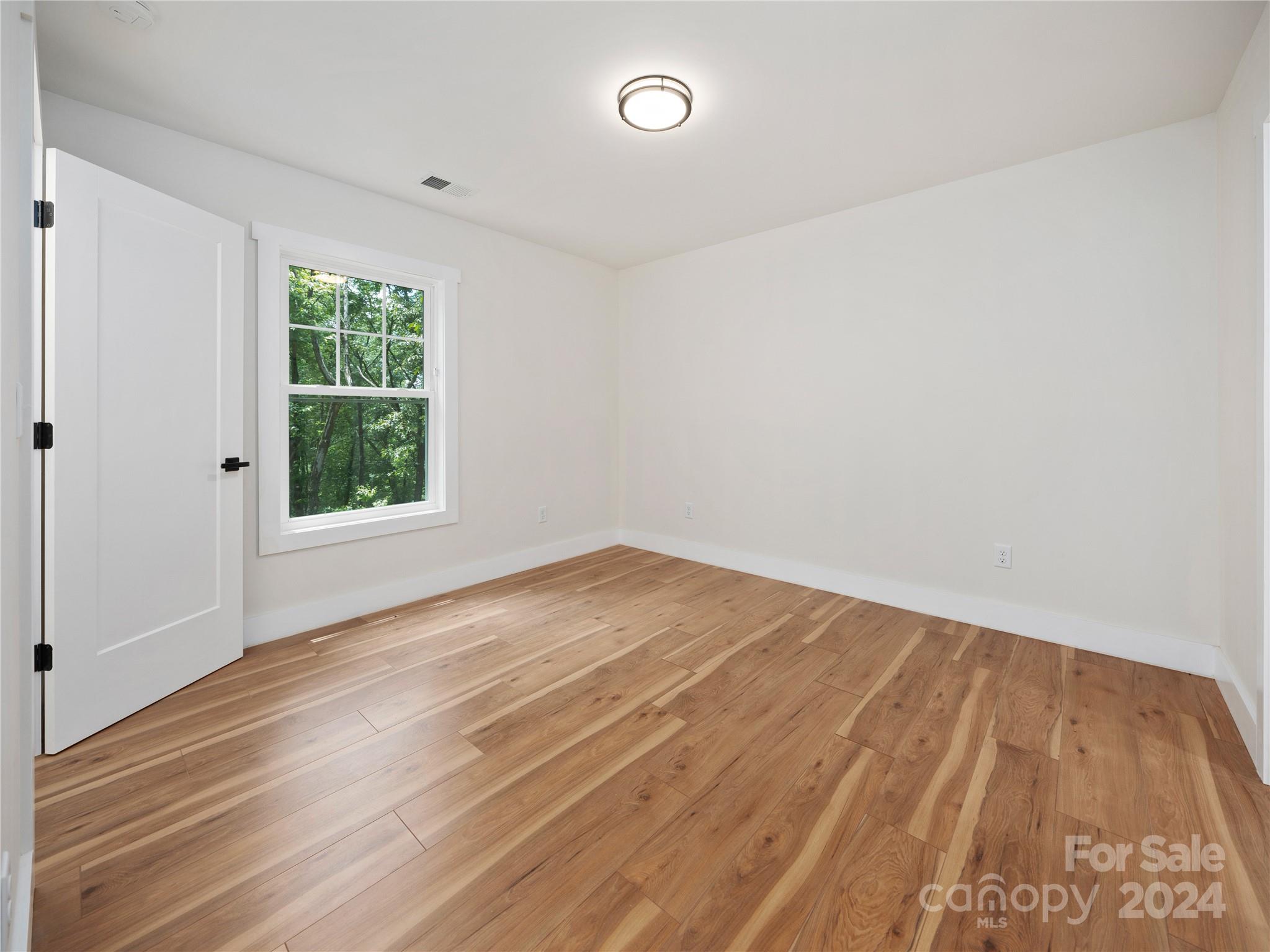 359 Tiptop Road Brevard, NC 28712 - Photo 38 of 48 an empty room with wooden floor and windows
