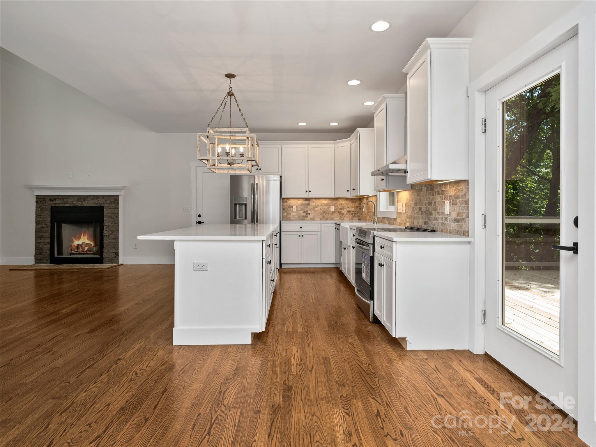 359 Tiptop Road Brevard, NC 28712 - Photo 9 of 48 a kitchen with wooden floors and white cabinets