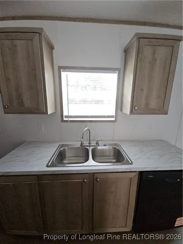 a kitchen with a sink a window and cabinets