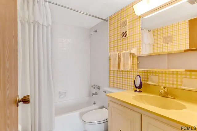 a bathroom with a sink a toilet and shower curtain