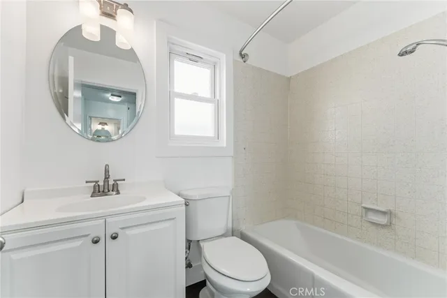 a bathroom with a toilet a sink a mirror and bathtub