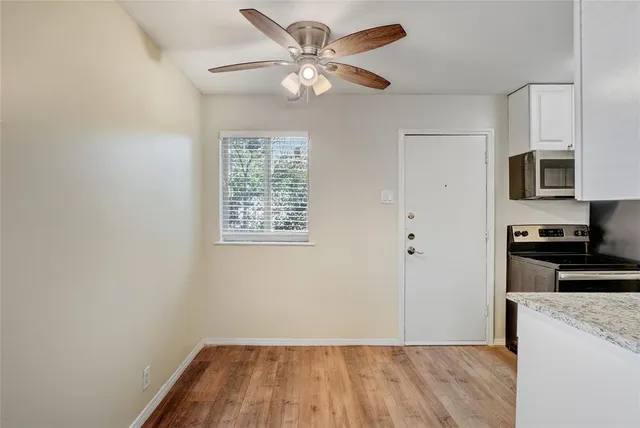 a view of a kitchen with wooden cabinet and a ceiling fan
