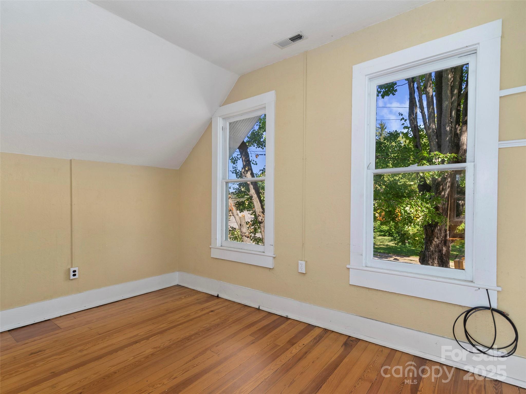 99 Walnut Street Waynesville, NC 28786 - Photo 18 of 34 a view of an empty room with a window and wooden floor