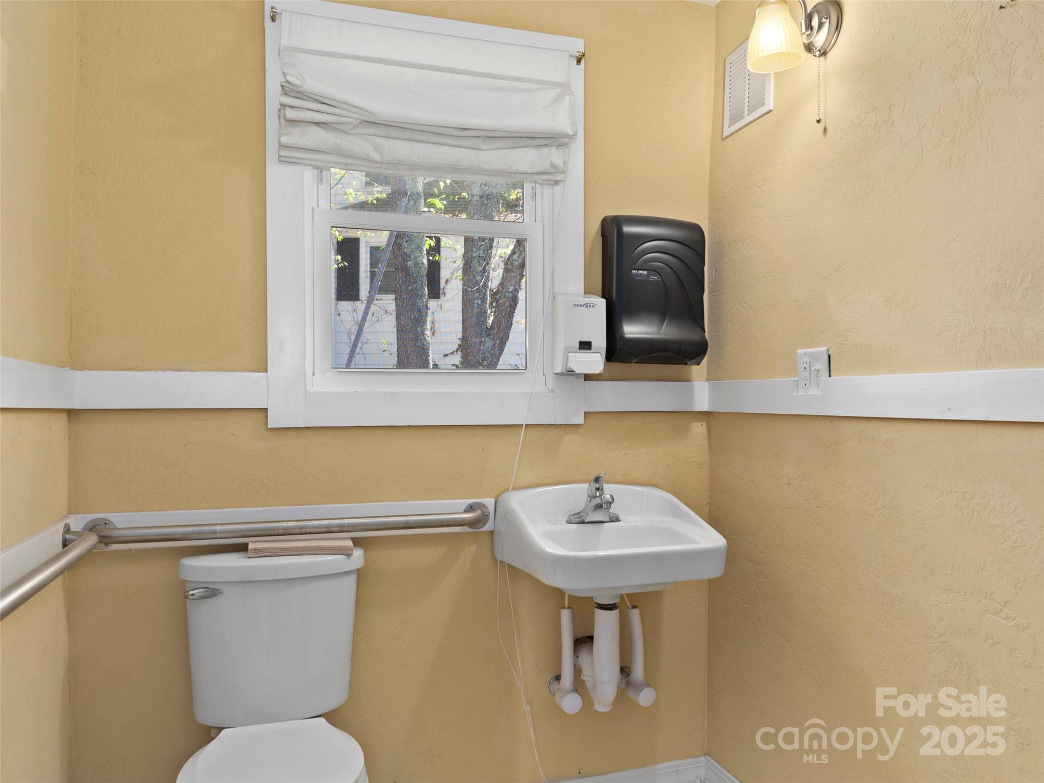 99 Walnut Street Waynesville, NC 28786 - Photo 10 of 34 a bathroom with a toilet a sink and mirror