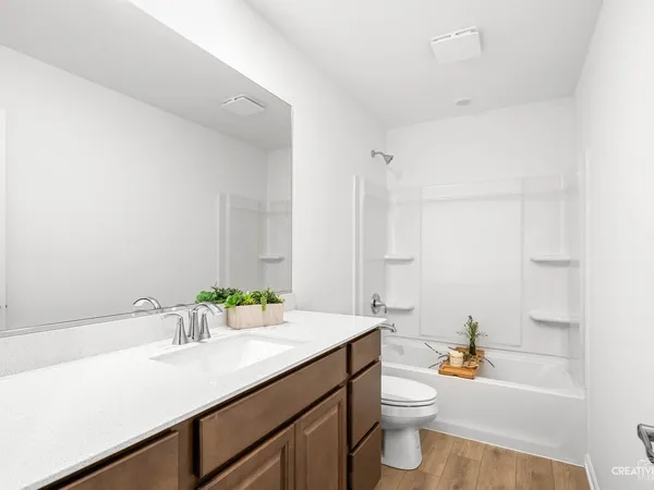 a bathroom with a granite countertop sink toilet and a bathtub